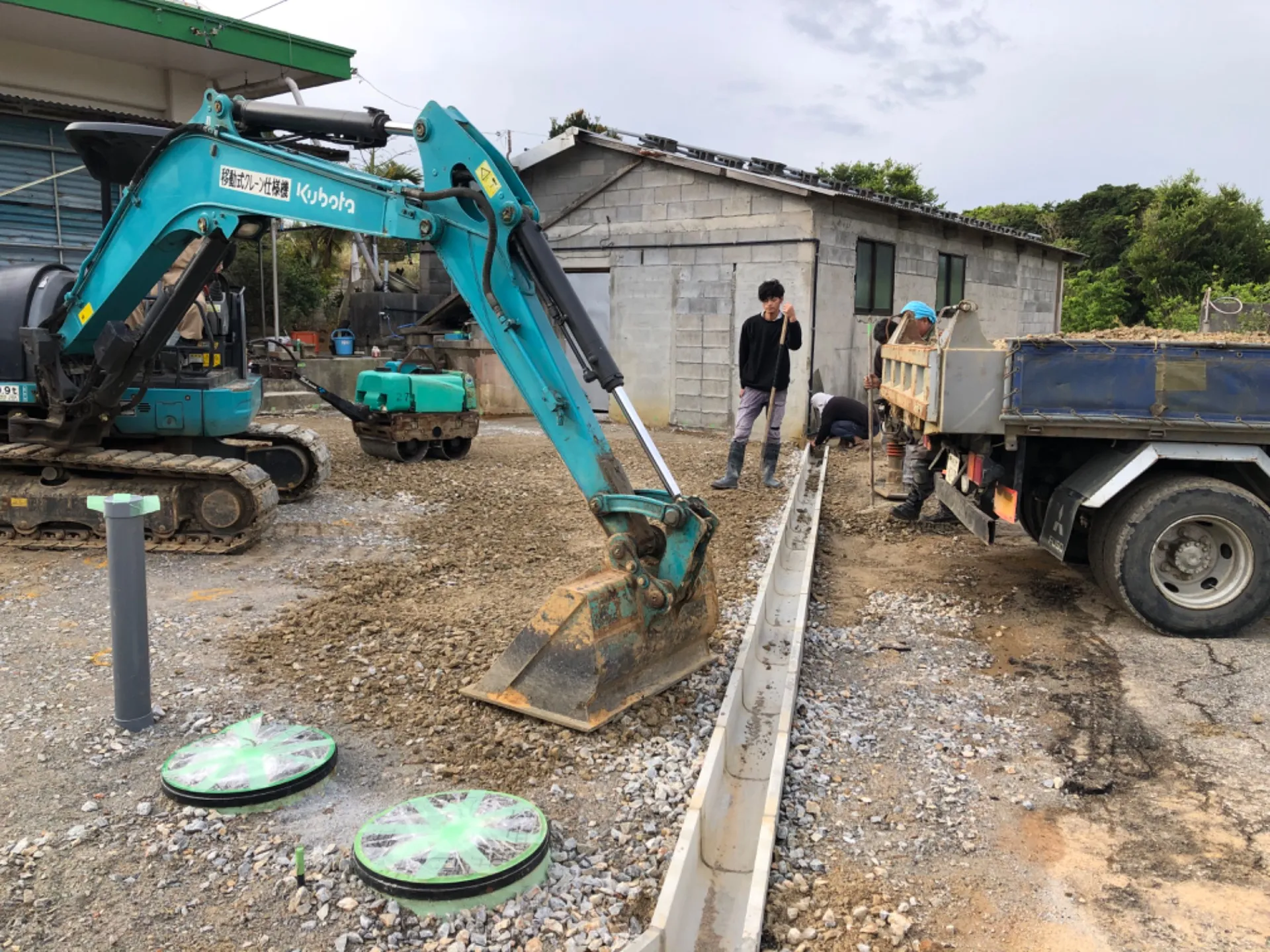 埋設浄化槽設置後、U字溝設置・重機、ローダーにて散水しながらしっかり転圧していきます。